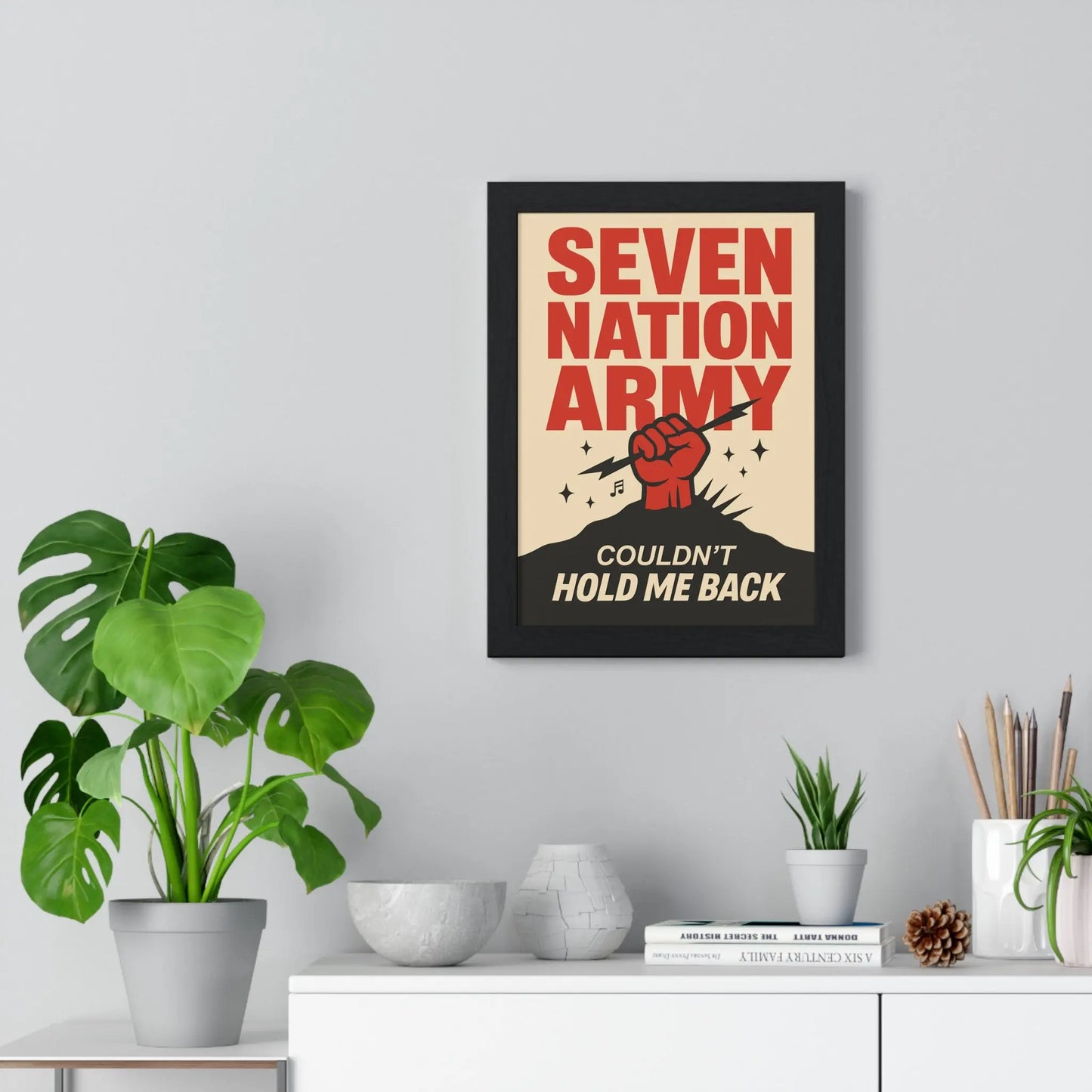 Framed poster with 'Seven Nation Army' design on a wall with decor elements.