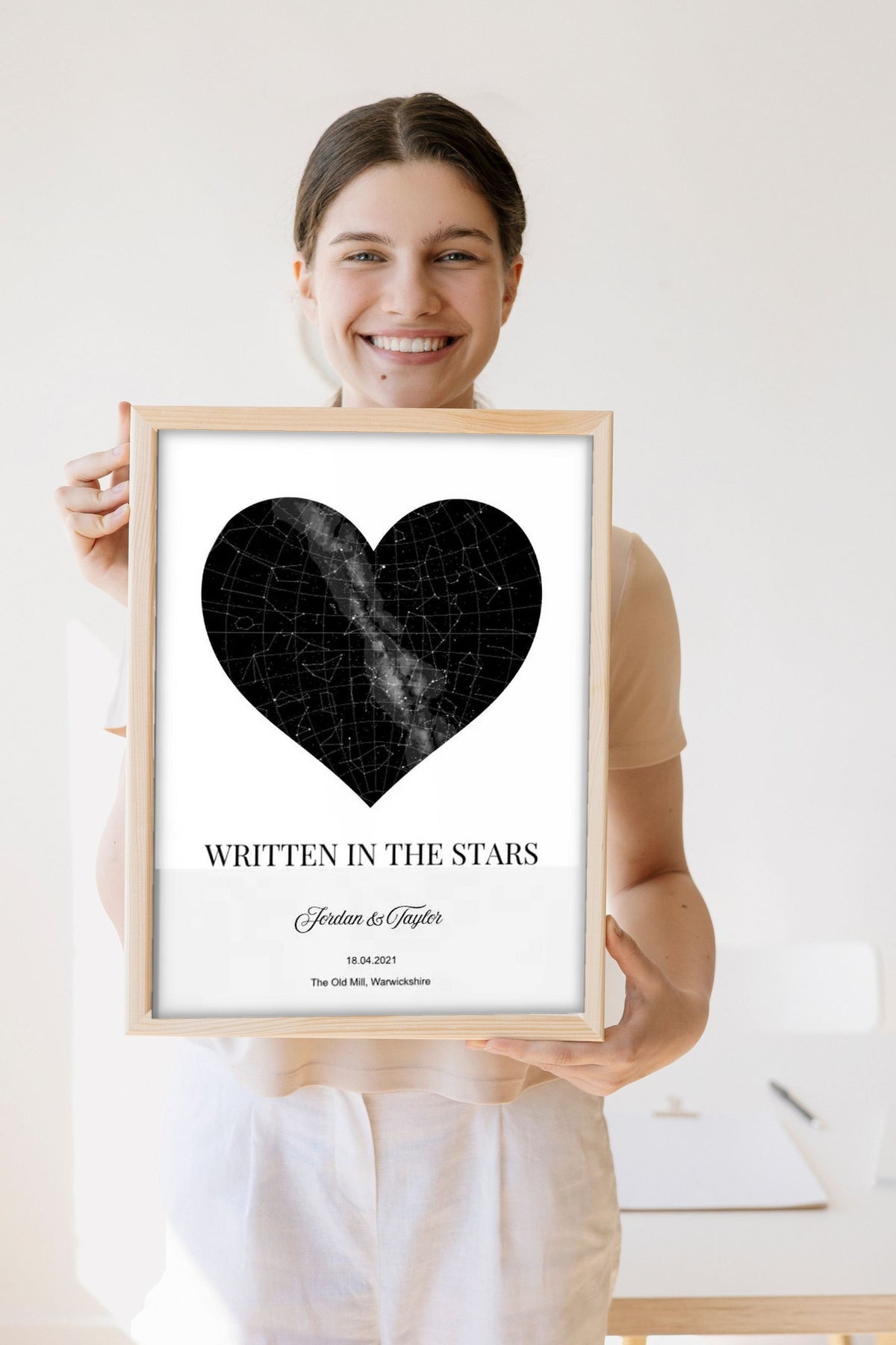 Lifestyle - Personalised Star Map Heart Print held by a smiling woman