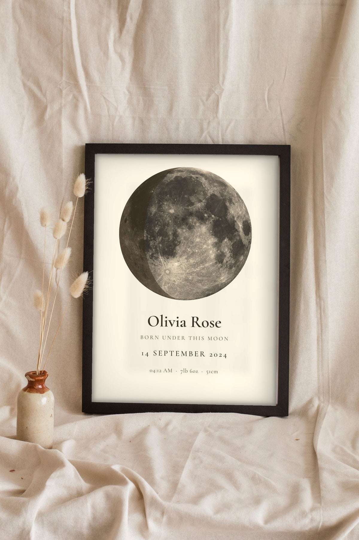 Lifestyle - Personalised New Baby Moon Phase Print leaning in a frame with dried flowers