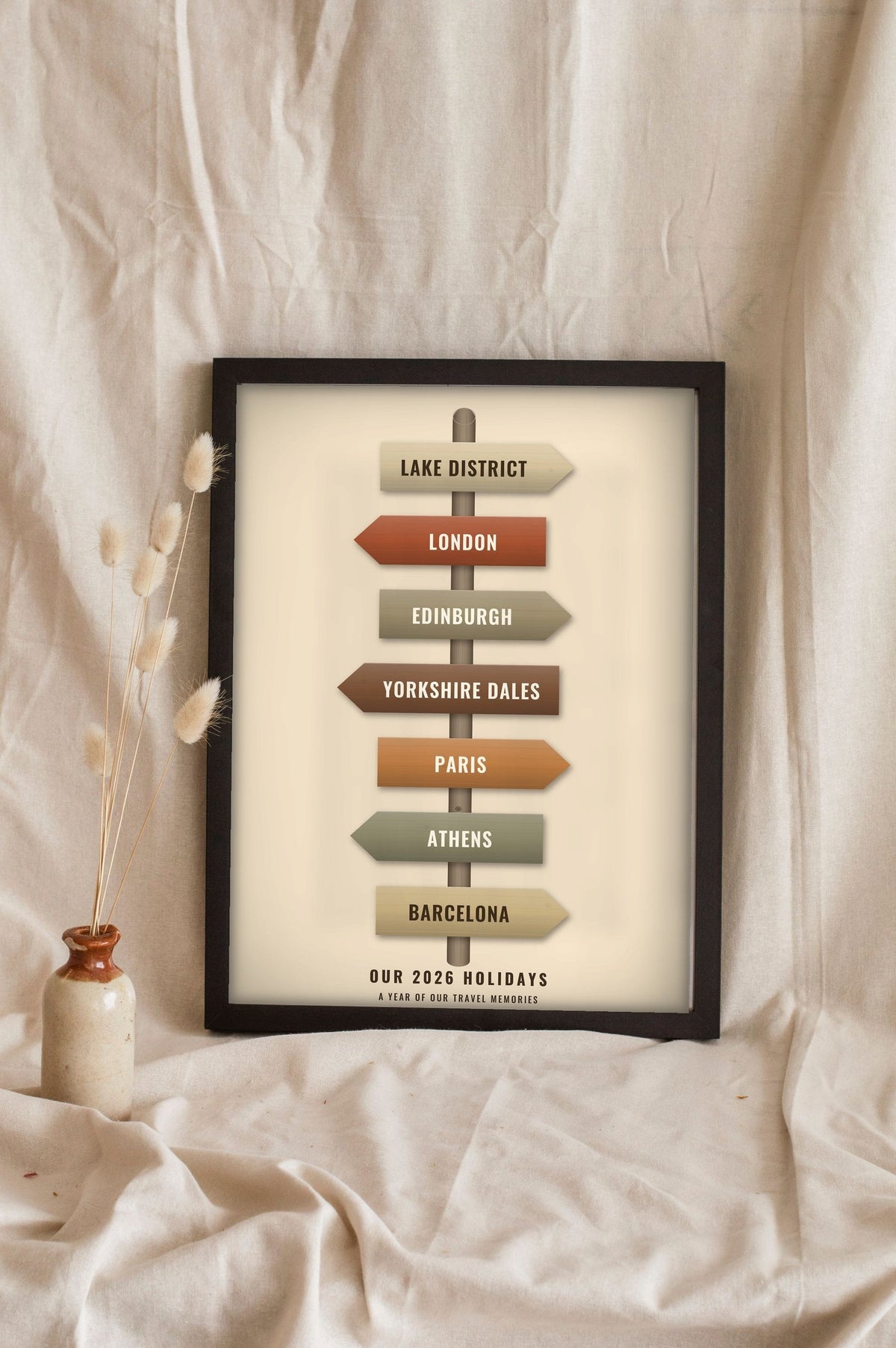 Lifestyle - Personalised Travel Signpost Print leaning in a frame with dried flowers