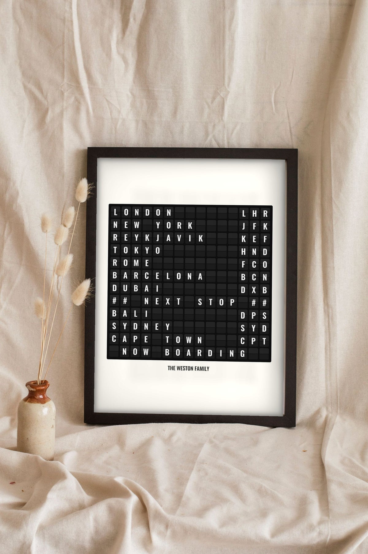 Lifestyle - Personalised Airport Destination Board Print leaning in a frame with dried flowers