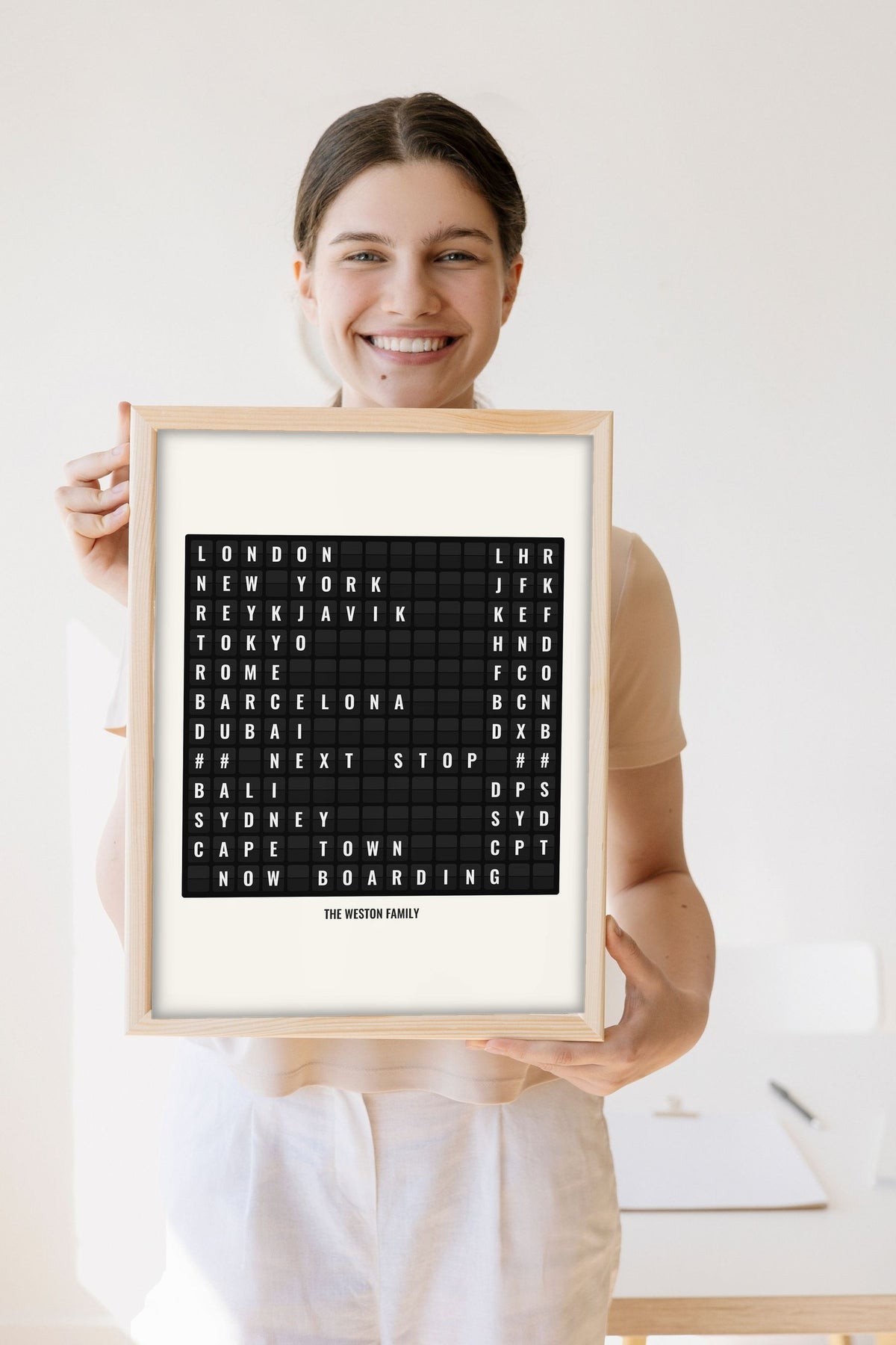 Lifestyle - Personalised Airport Destination Board Print held by a smiling woman