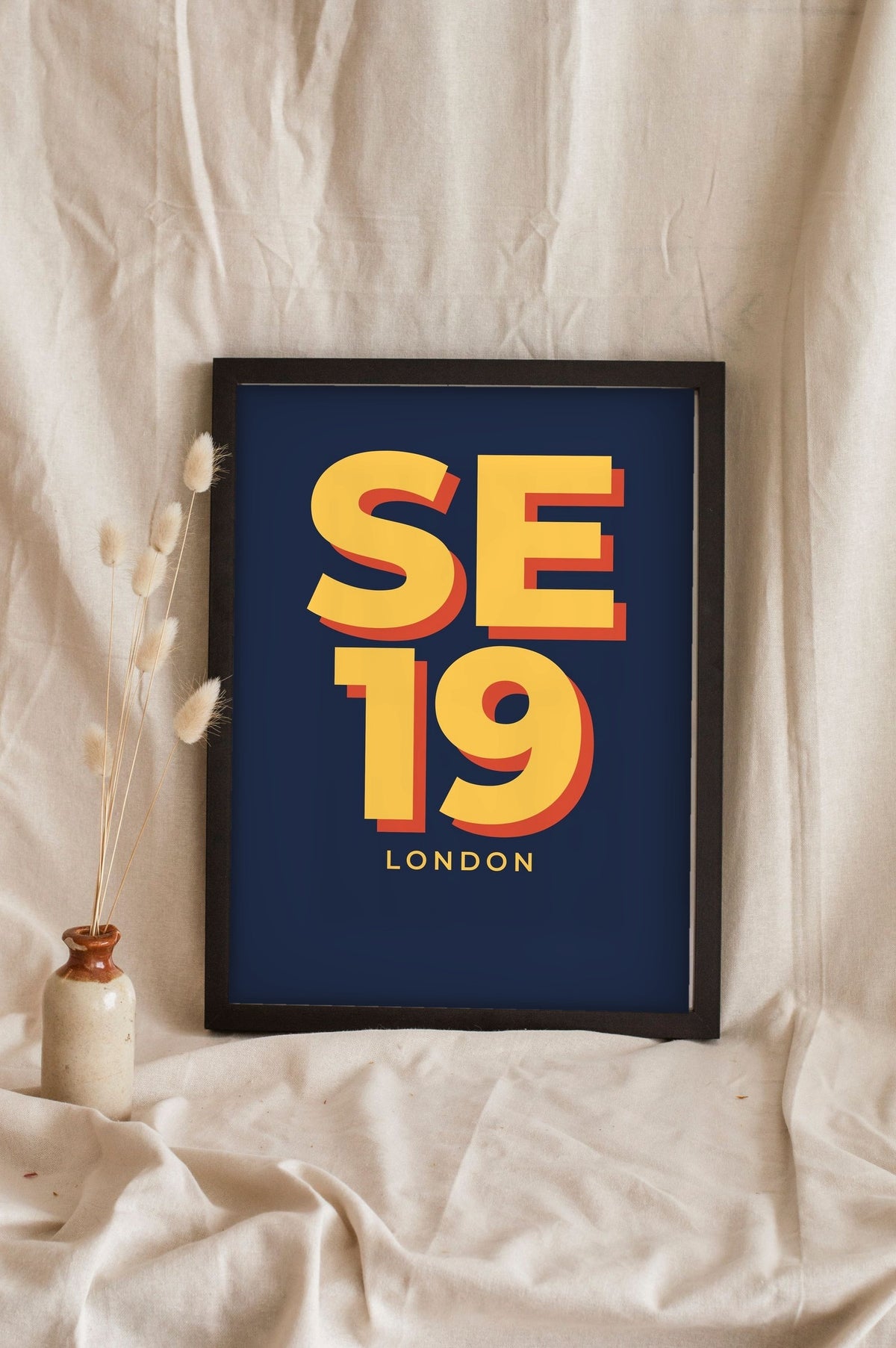 Lifestyle - Personalised Postcode Print leaning in a frame with dried flowers