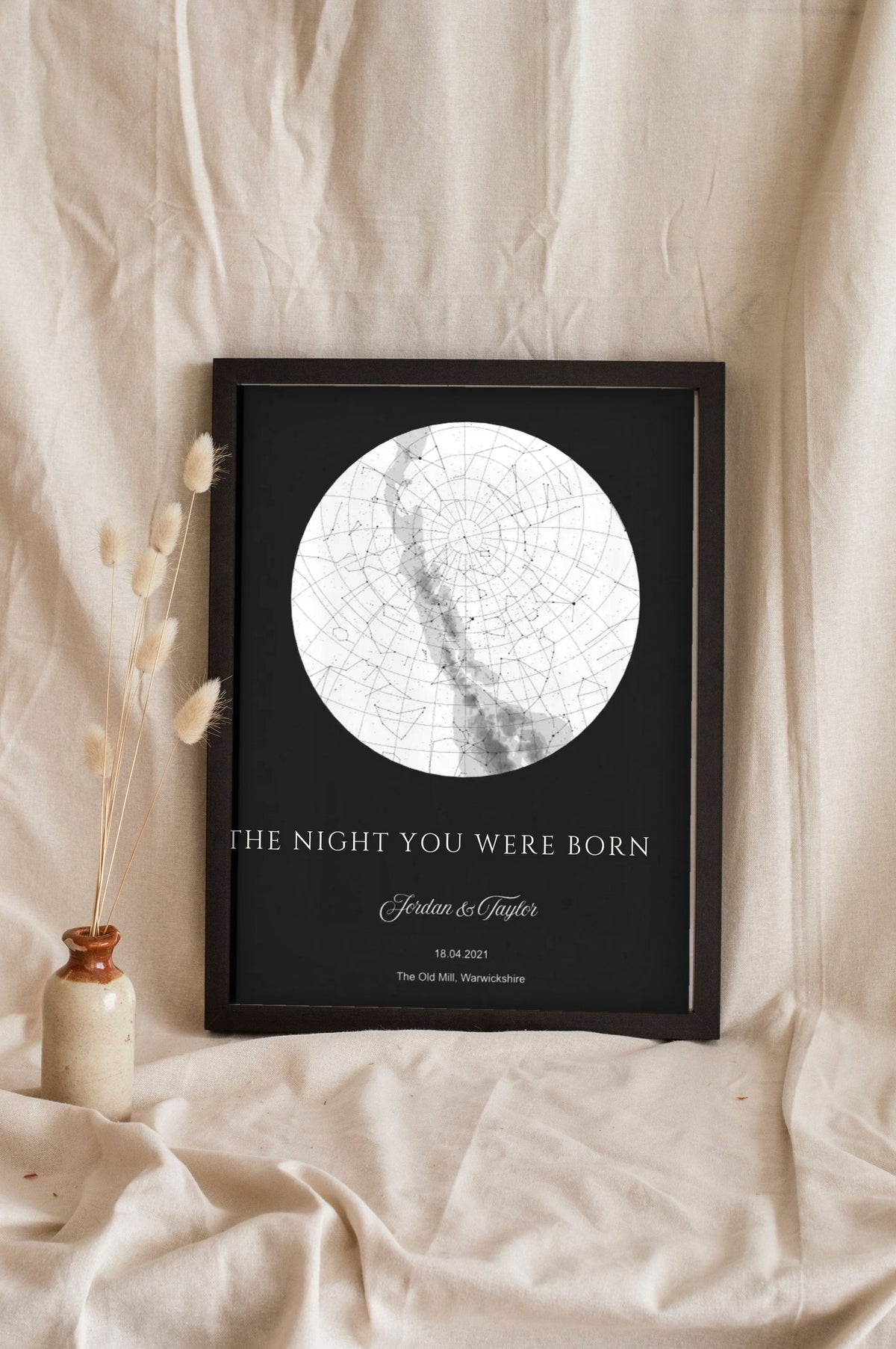 Lifestyle - Personalised The Night You Were Born Star Map Print – Black leaning in a frame with dried flowers