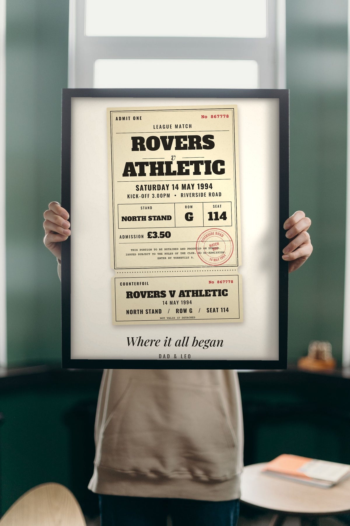 Lifestyle - Personalised Vintage Football Ticket Print held up in a bright room