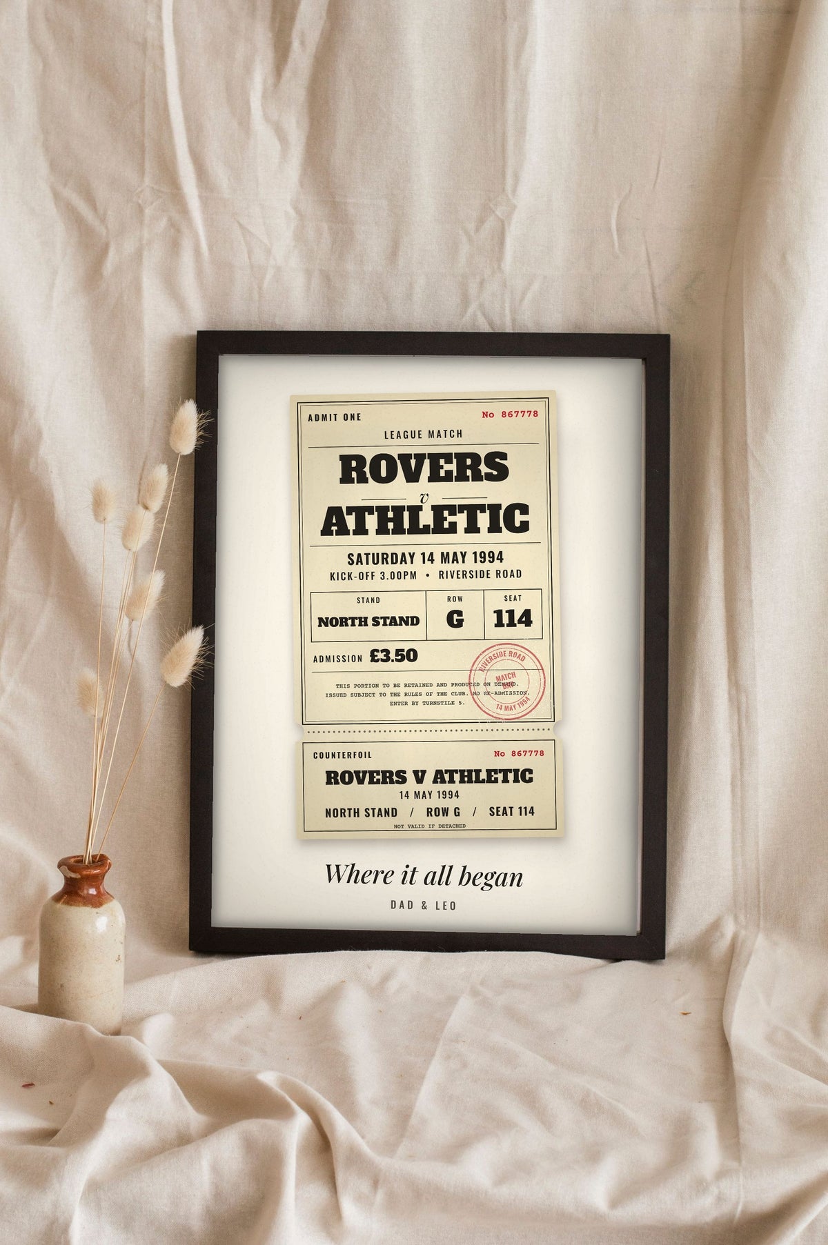Lifestyle - Personalised Vintage Football Ticket Print leaning in a frame with dried flowers