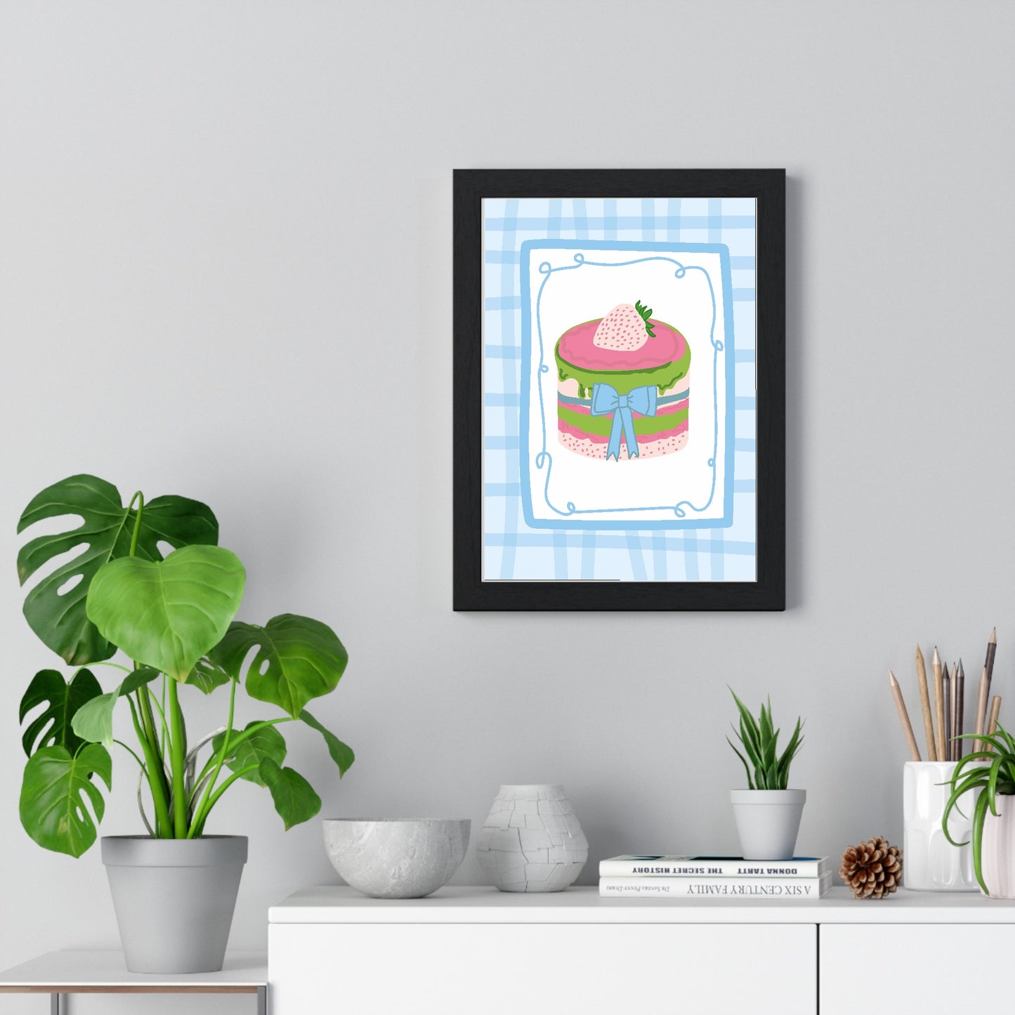 Strawberry and matcha cake poster framed on a kitchen wall above a wooden table