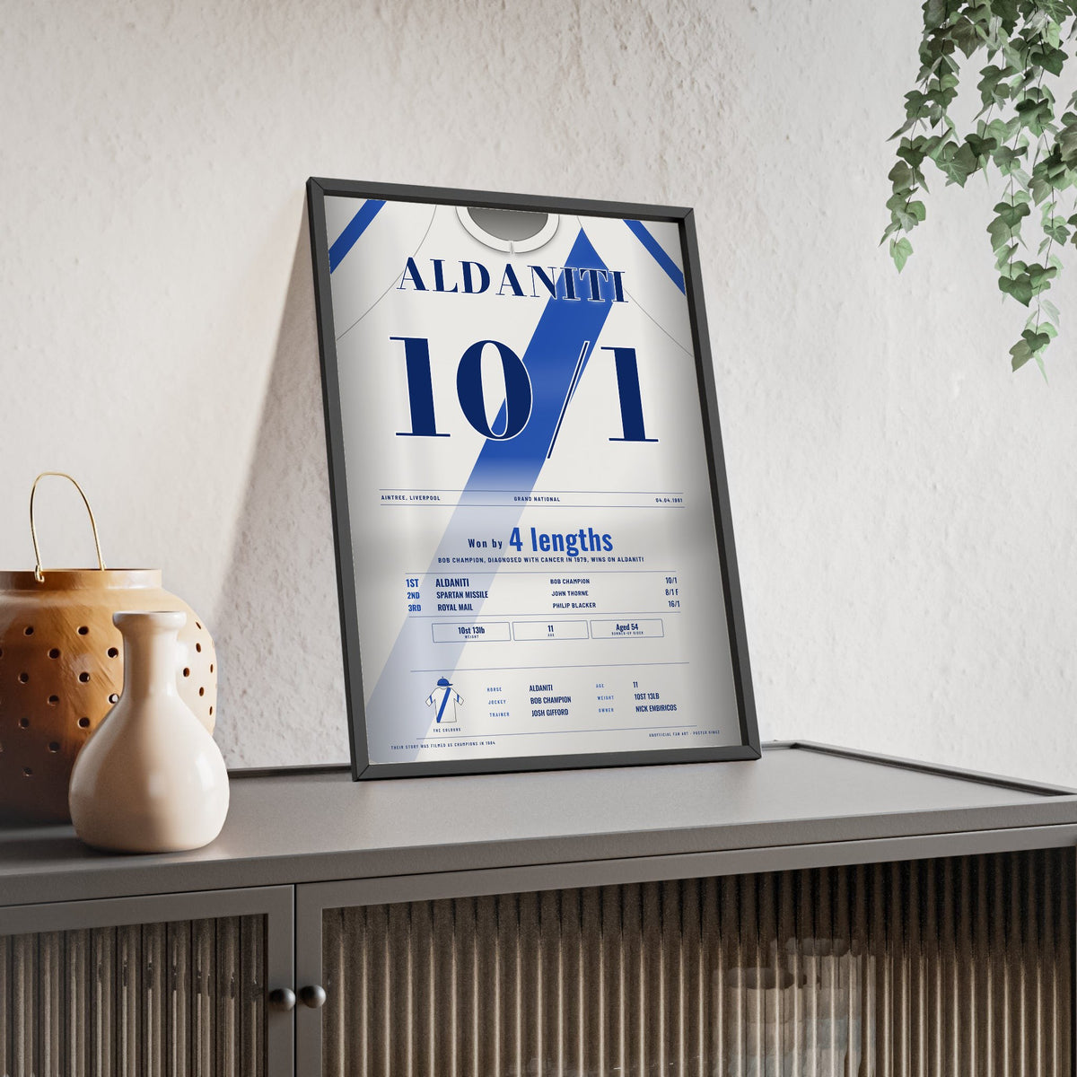 Aldaniti Grand National 1981 Horse Racing Poster - Bob Champion Silks Print framed and leaning on a sideboard