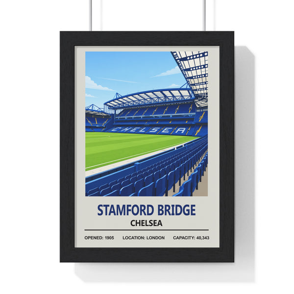 A framed art print of Stamford Bridge football stadium in Chelsea, featuring a stylized illustration of the blue stadium seating and green pitch under a blue sky, presented in a black frame against a white background.