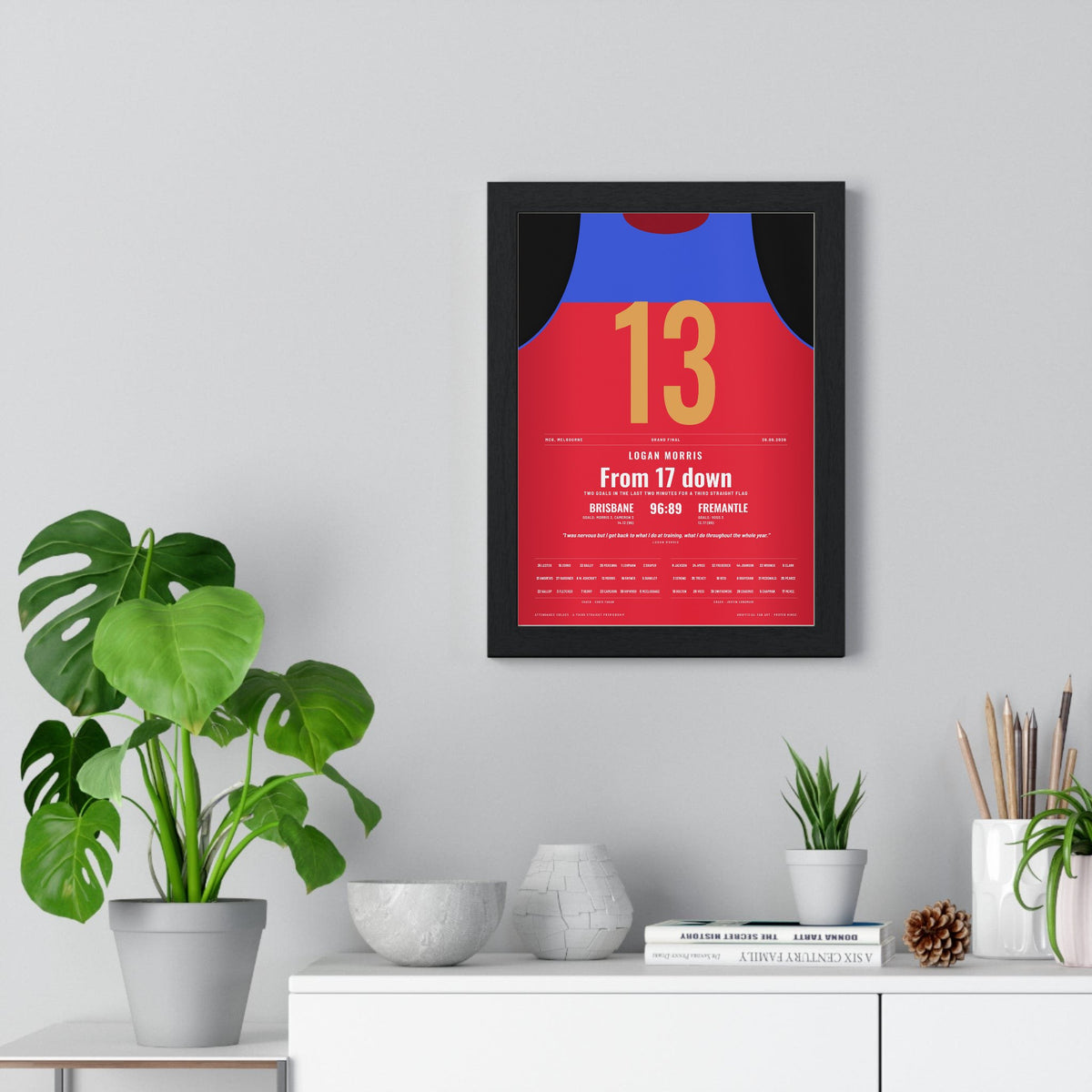 Brisbane Lions AFL Grand Final 2026 Poster - Logan Morris 13 MCG Guernsey Print framed on a living room wall