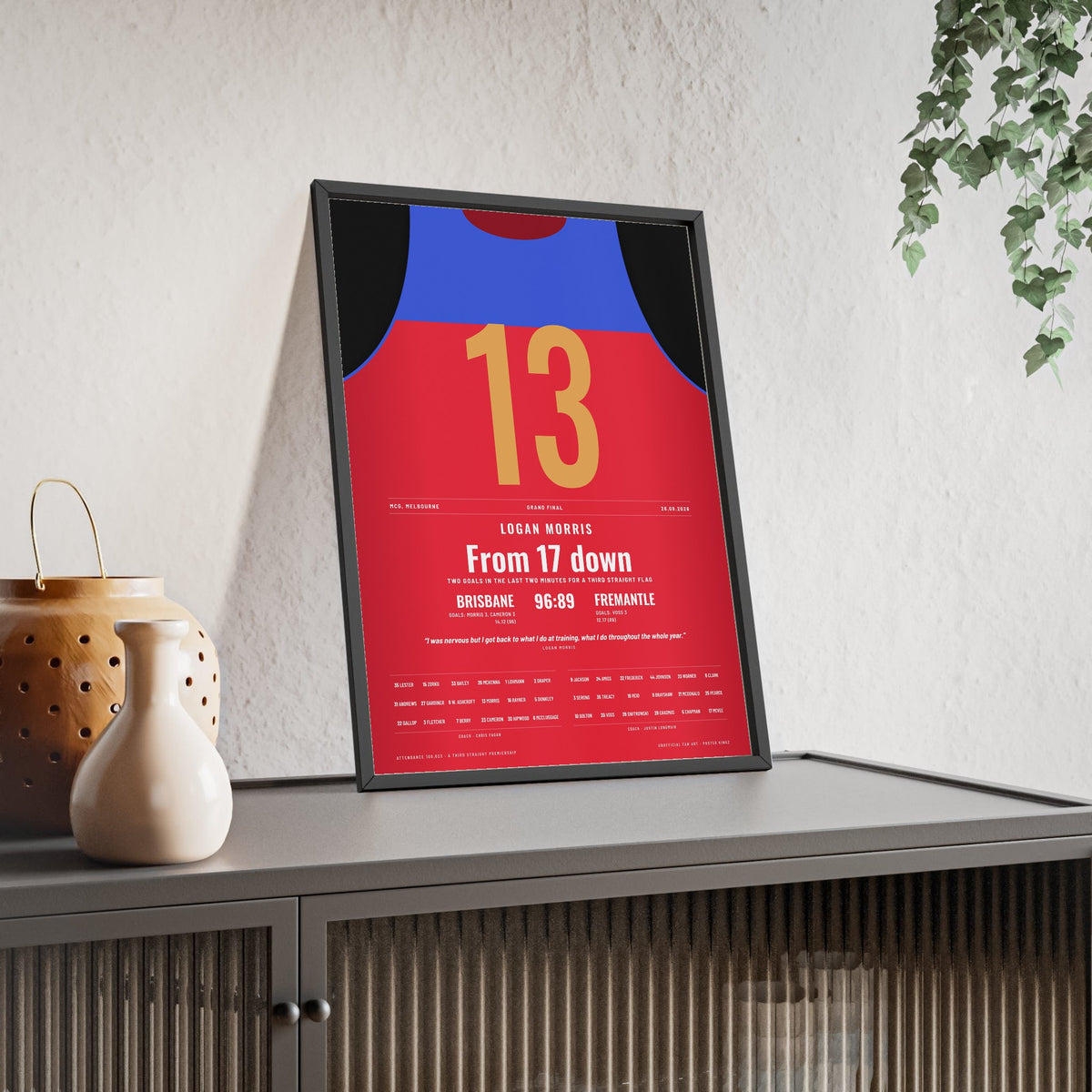 Brisbane Lions AFL Grand Final 2026 Poster - Logan Morris 13 MCG Guernsey Print framed and leaning on a sideboard