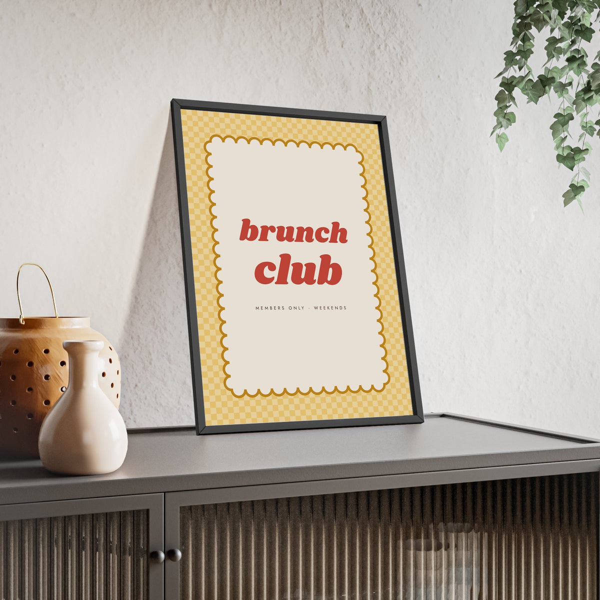 Brunch Club Print framed and leaning on a sideboard