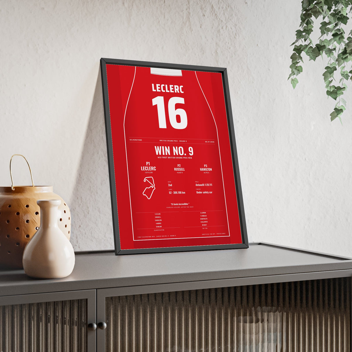 Charles Leclerc 2026 British Grand Prix Win Poster - 16 Race Suit Print framed and leaning on a sideboard