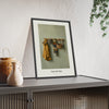 Coats on Pegs Print framed and leaning on a sideboard