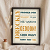 Cornish Slang Print in a black frame propped up on linen