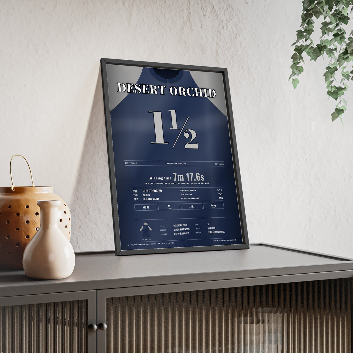 Desert Orchid Cheltenham Gold Cup 1989 Horse Racing Poster - Heavy Ground Win Silks Print framed and leaning on a sideboard