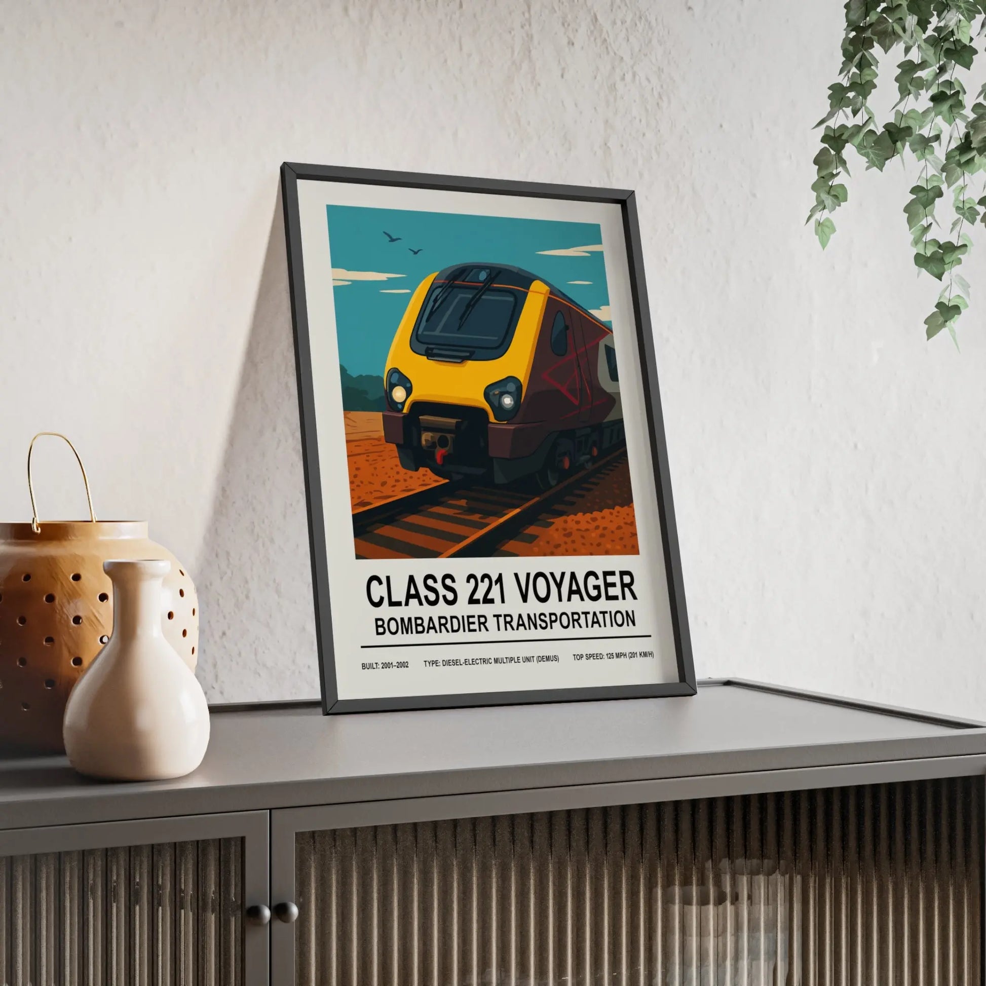 Framed poster of a train labeled 'Class 221 Voyager' by Bombardier Transportation on a shelf.