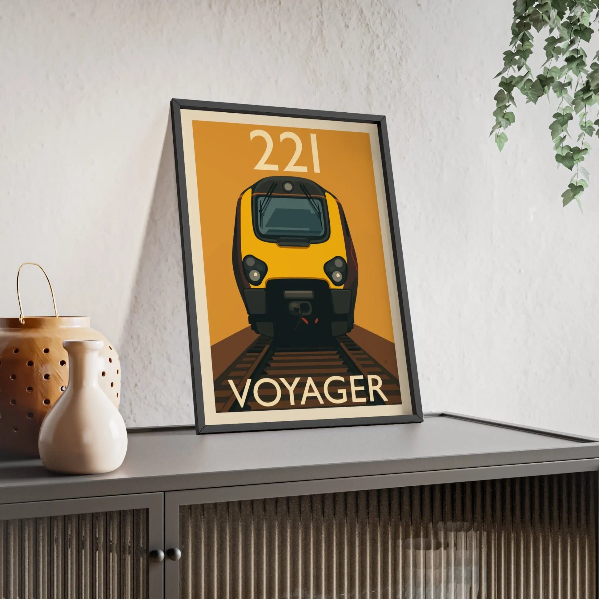 Framed poster of a train labeled 'Voyager' on a shelf with decorative items.