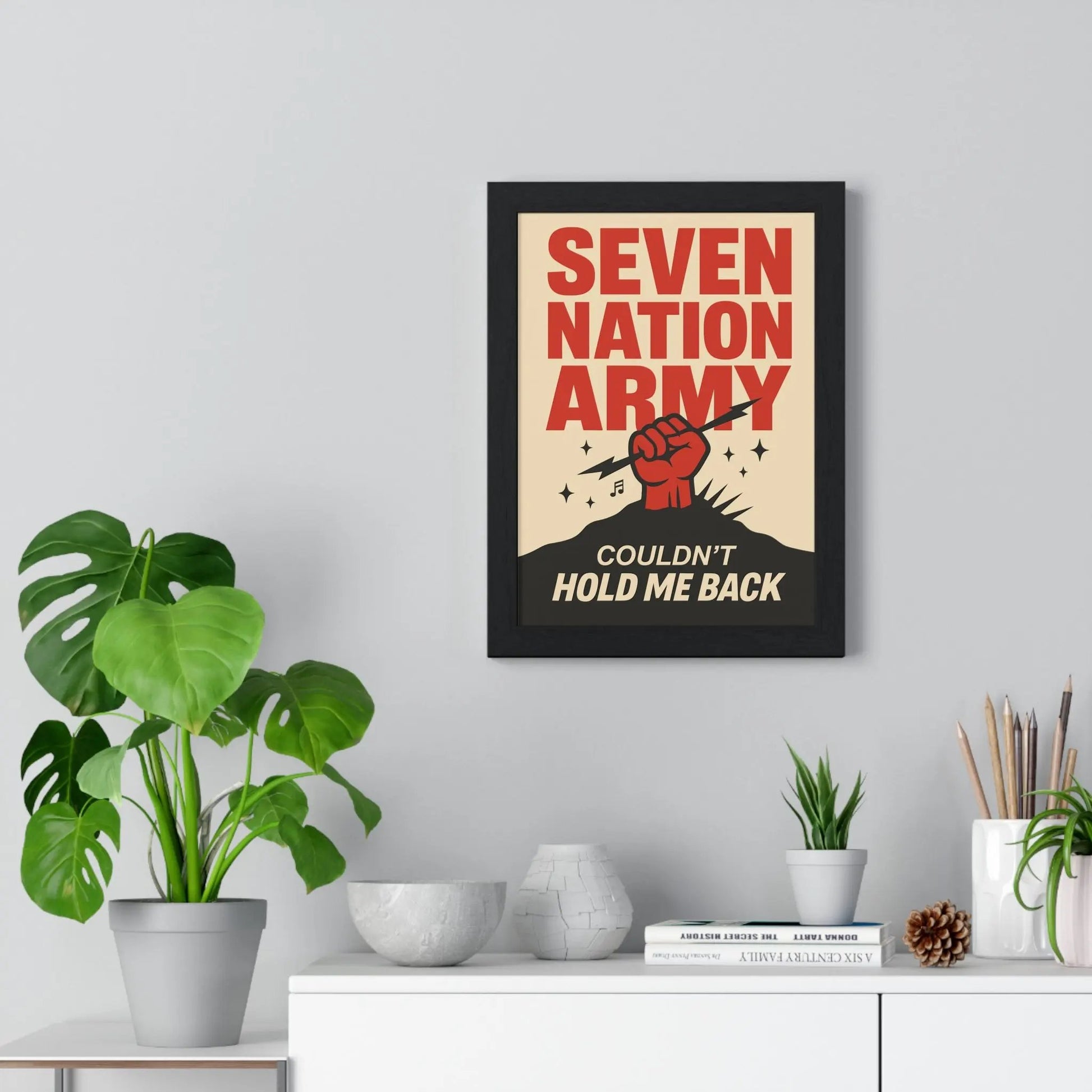 Framed poster with 'Seven Nation Army' design on a wall with decor elements.
