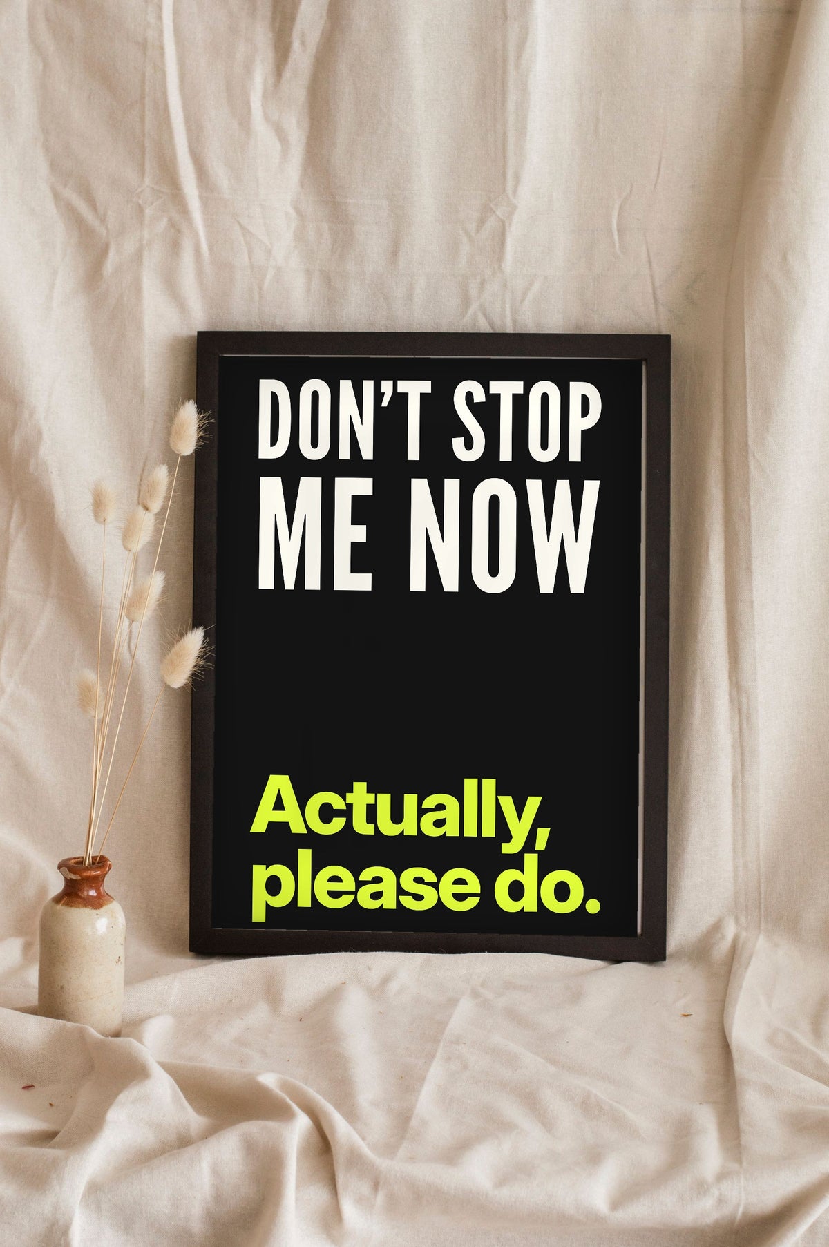 Funny Don't Stop Me Now lyric print in a black frame propped up on linen