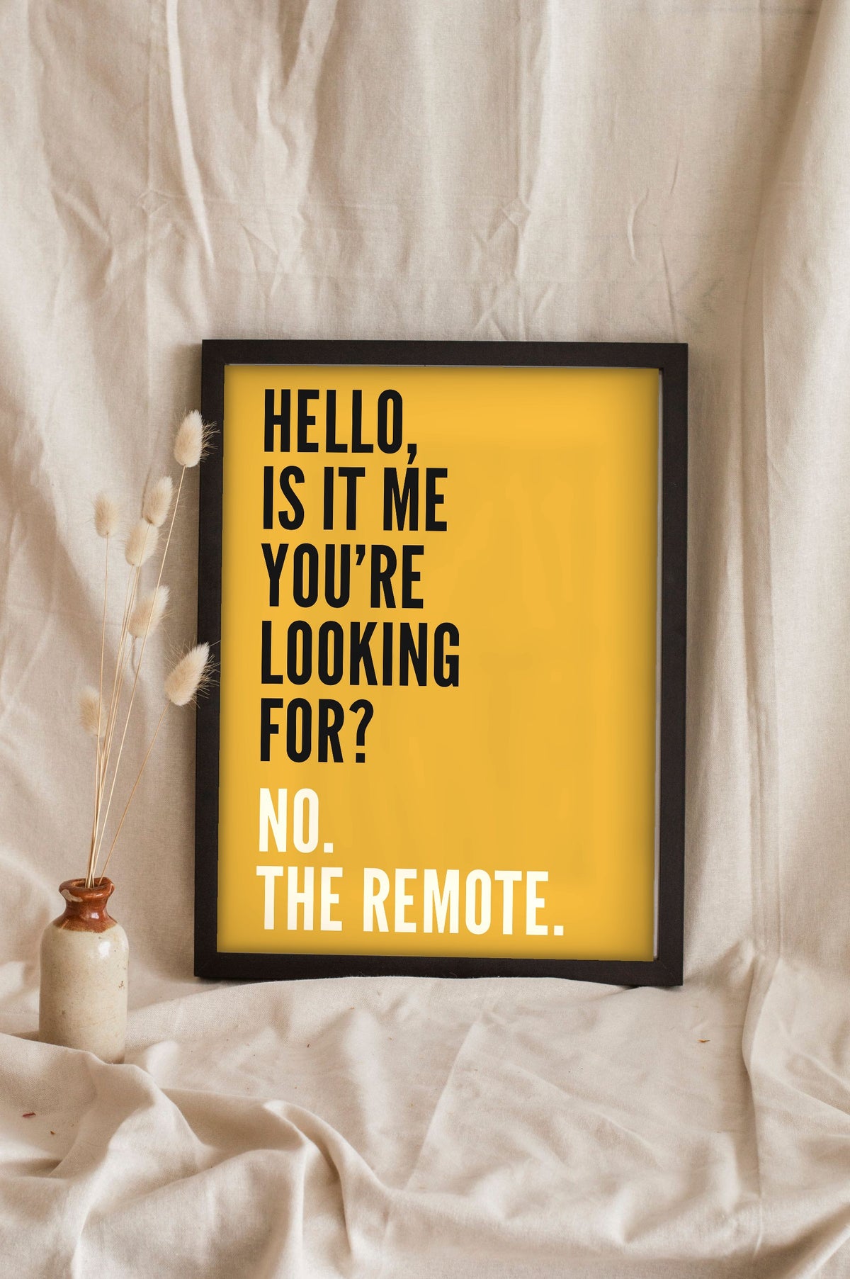 Funny Hello lyric print in a black frame propped up on linen