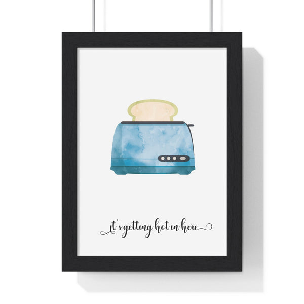 Framed funny kitchen poster with blue watercolour toaster and 'It's Getting Hot in Here' text on white wall