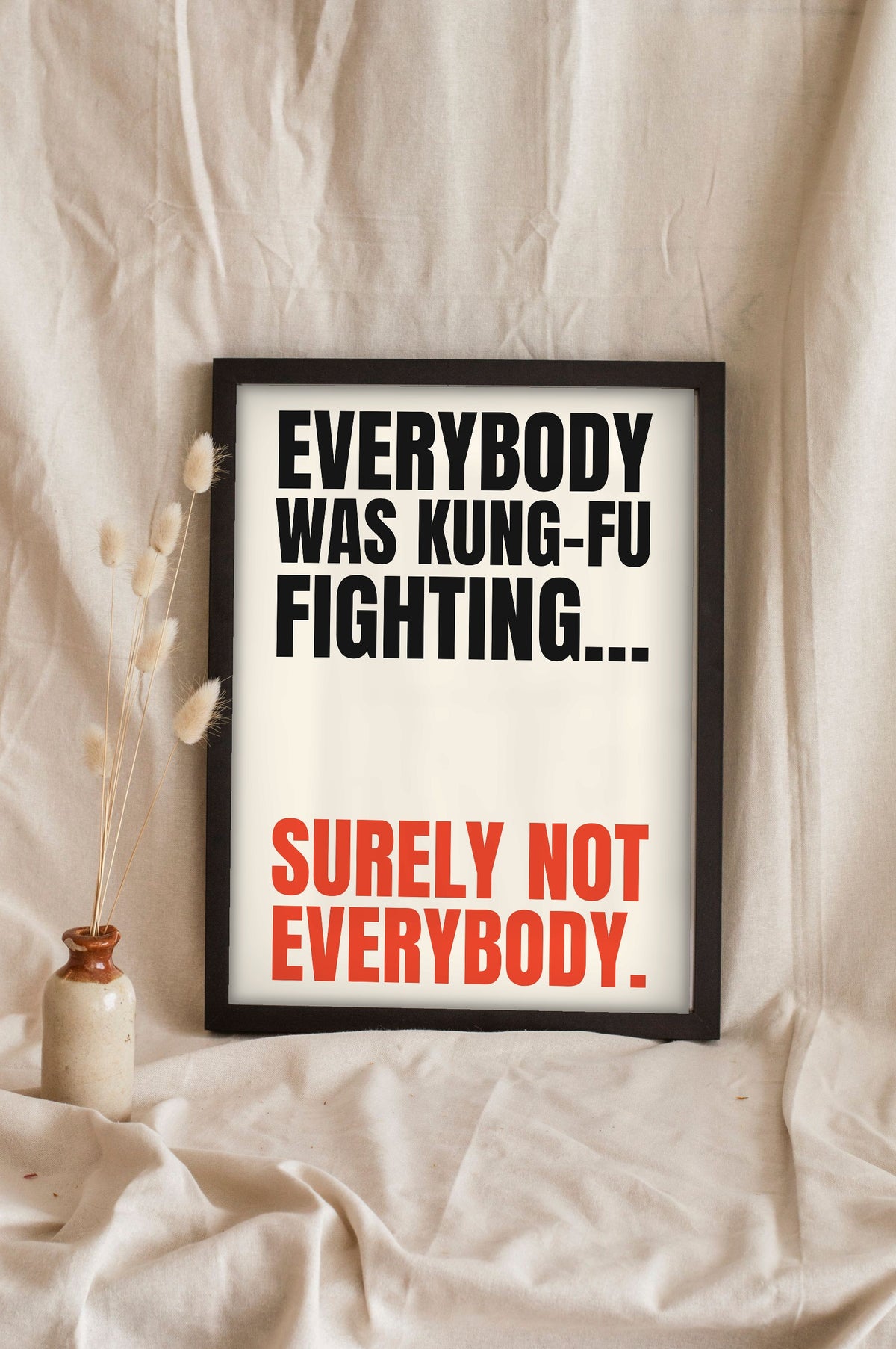 Funny Kung Fu Fighting lyric print in a black frame propped up on linen