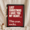 Funny Last Christmas lyric print in a black frame propped up on linen