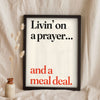 Funny Livin' on a Prayer lyric print in a black frame propped up on linen