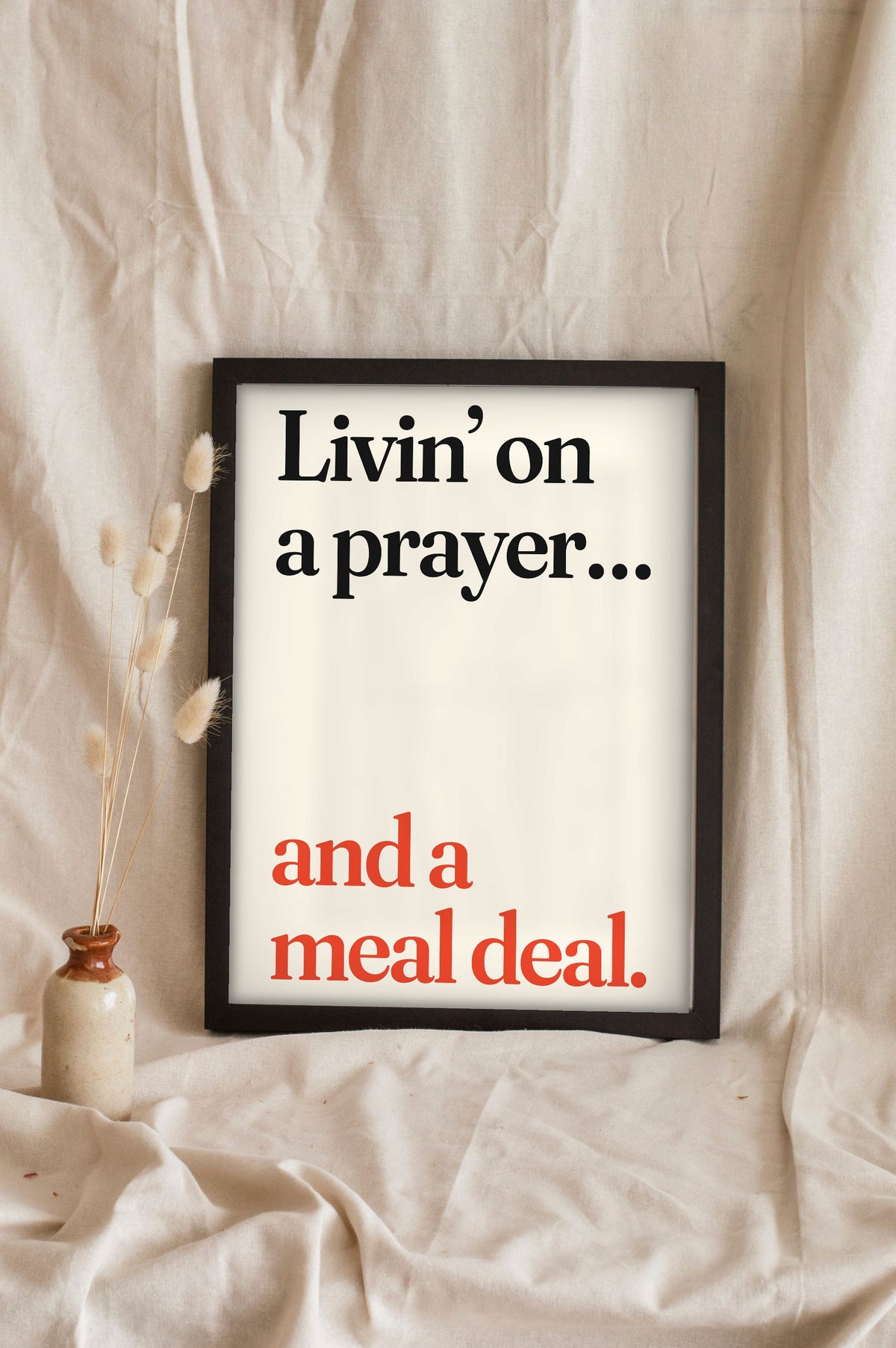 Funny Livin' on a Prayer lyric print in a black frame propped up on linen