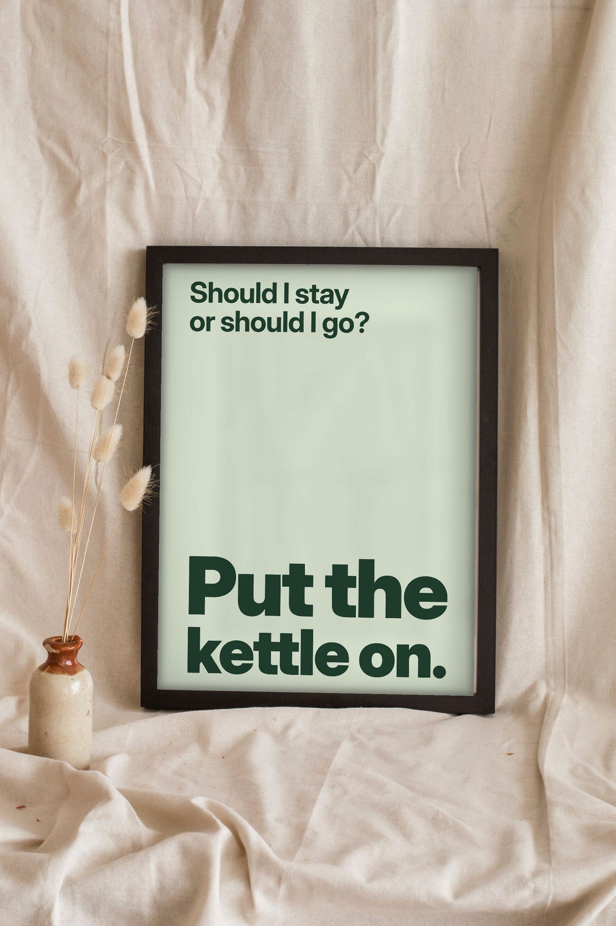 Funny Should I Stay or Should I Go lyric print in a black frame propped up on linen