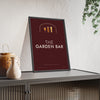 The Garden Bar Sign Print framed and leaning on a sideboard
