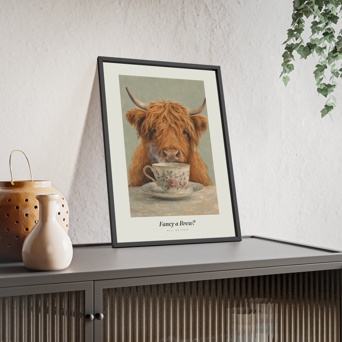 Highland Cow Tea Print framed and leaning on a sideboard