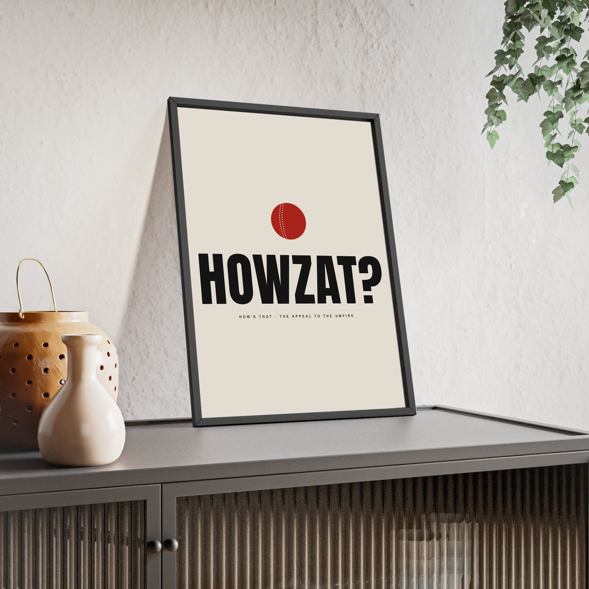 Howzat Cricket print framed and leaning on a sideboard