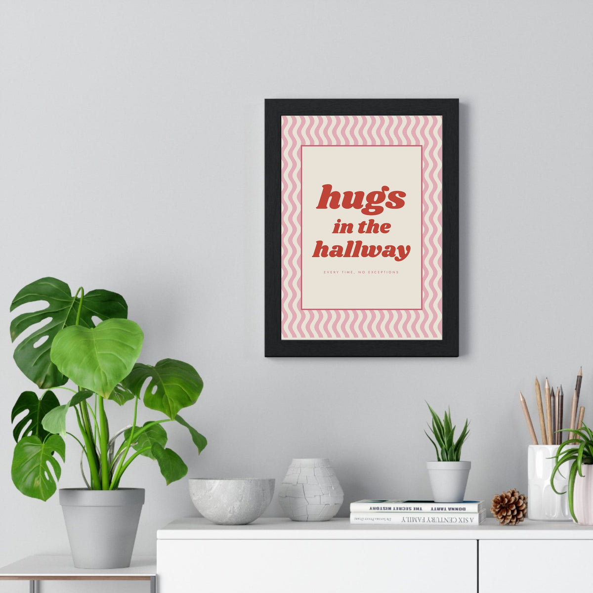 Hugs in the Hallway Print framed on a living room wall