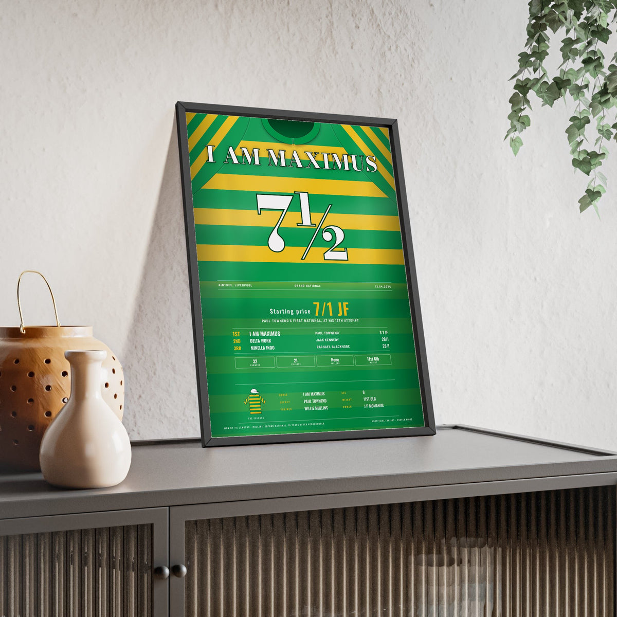 I Am Maximus Grand National 2024 Horse Racing Poster - Won by 7½ Lengths Silks Print framed and leaning on a sideboard