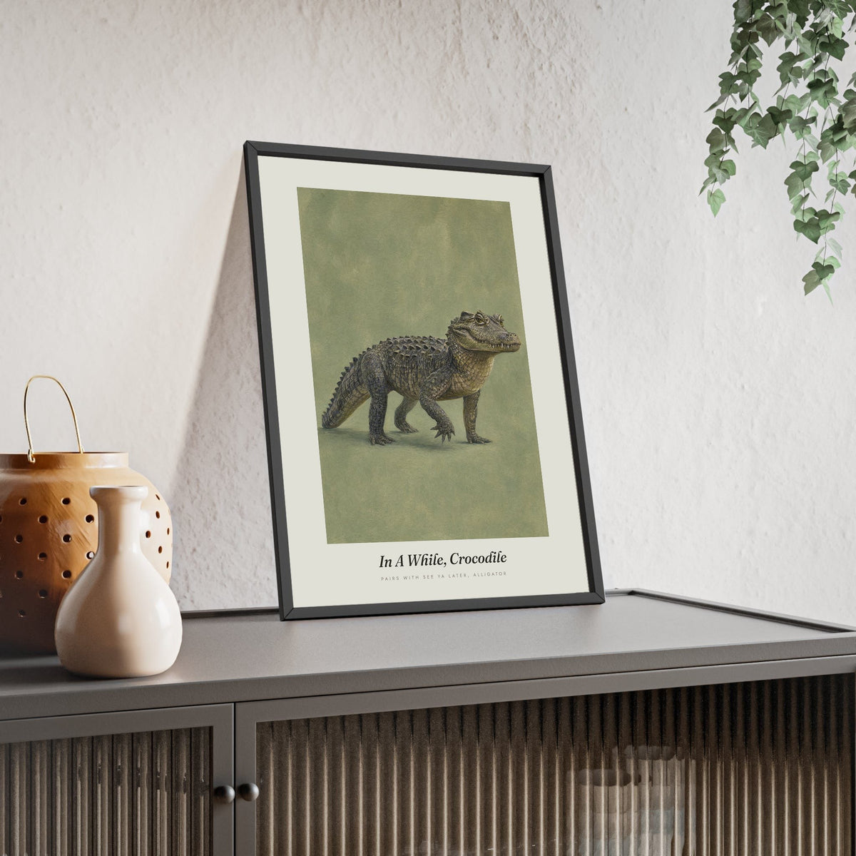 In a While Crocodile Print framed and leaning on a sideboard