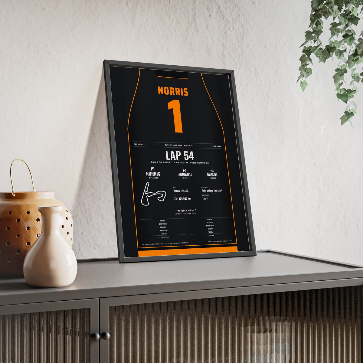 Lando Norris 2026 Dutch Grand Prix Win Poster - 1 Race Suit Print framed and leaning on a sideboard