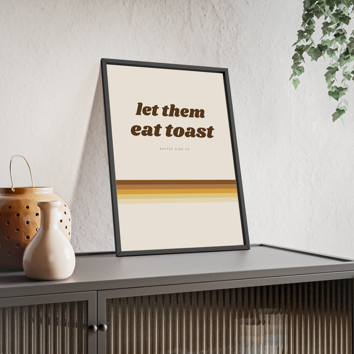 Let Them Eat Toast Print framed and leaning on a sideboard