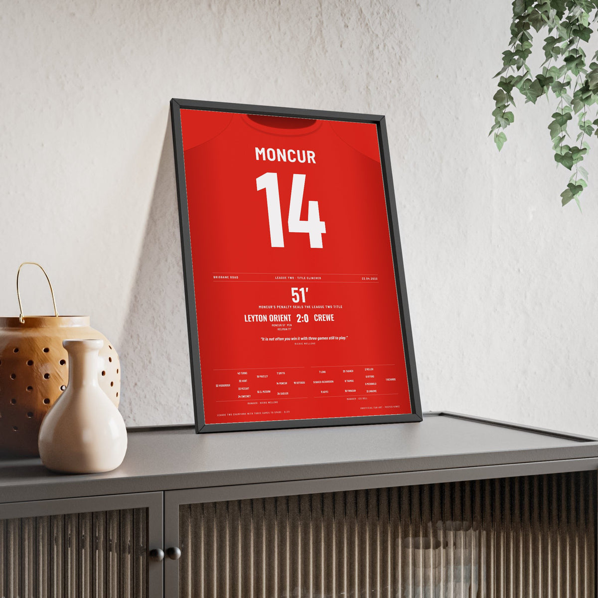 Leyton Orient League Two Champions 2023 Poster - George Moncur 14 Shirt Print framed and leaning on a sideboard