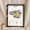 Manchester Sayings Print in a black frame propped up on linen