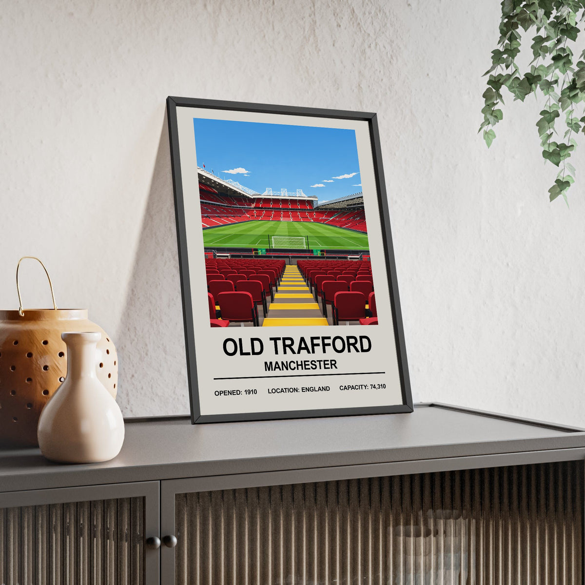 Manchester United Old Trafford print framed and leaning on a sideboard