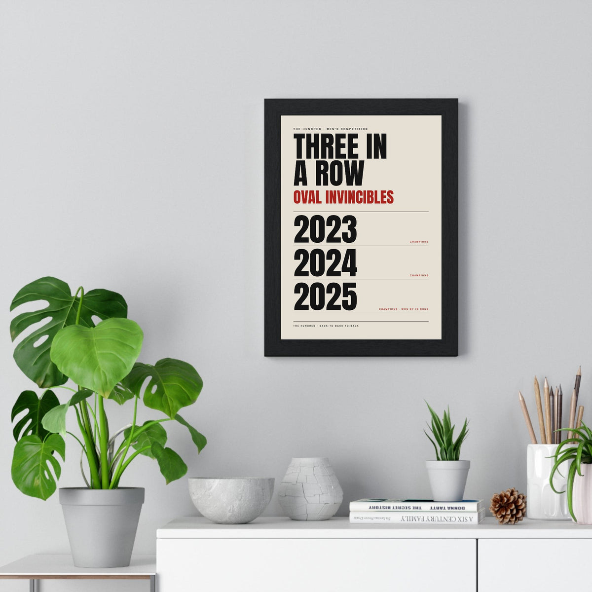 Oval Invincibles Hundred Champions 2023-2025 print framed on a living room wall