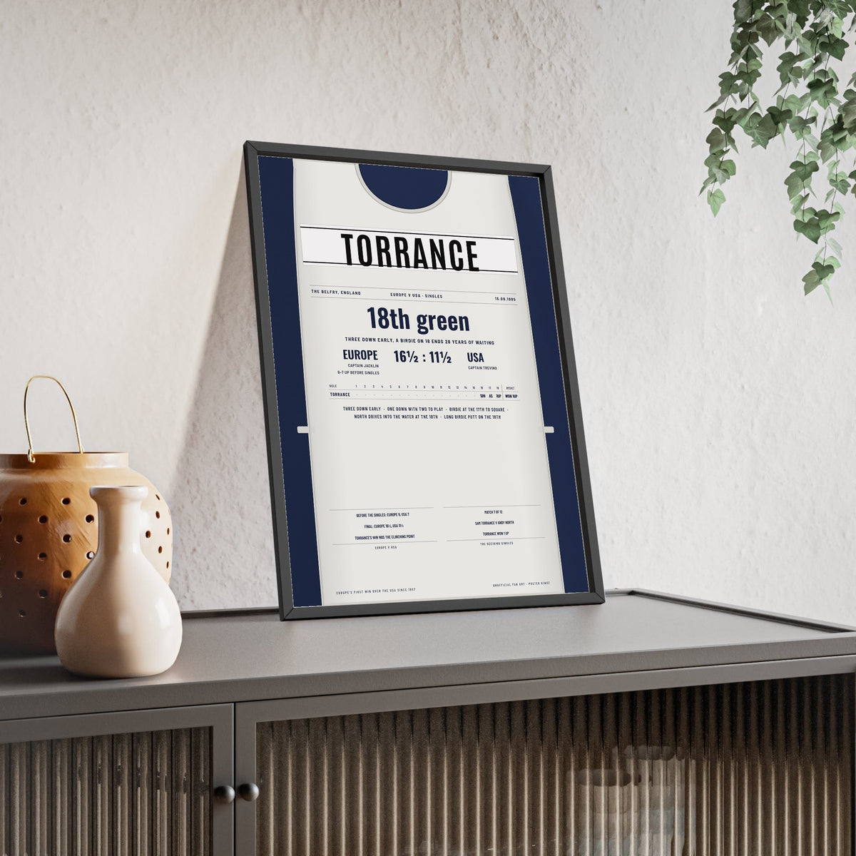 Sam Torrance The Belfry 1985 Golf Poster - Caddie Bib Europe v USA Winning Putt Print framed and leaning on a sideboard