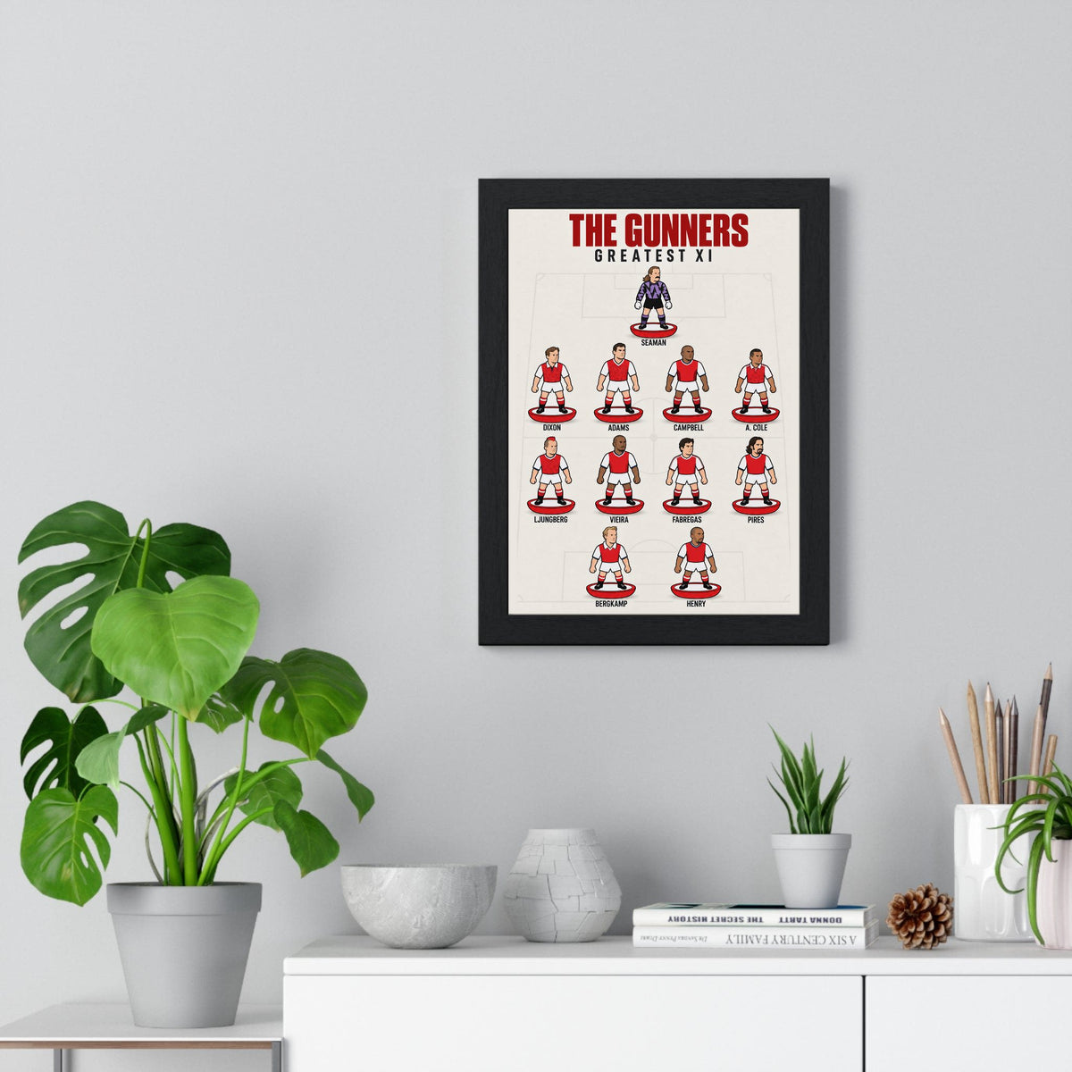 Arsenal Greatest XI poster framed on a living room wall