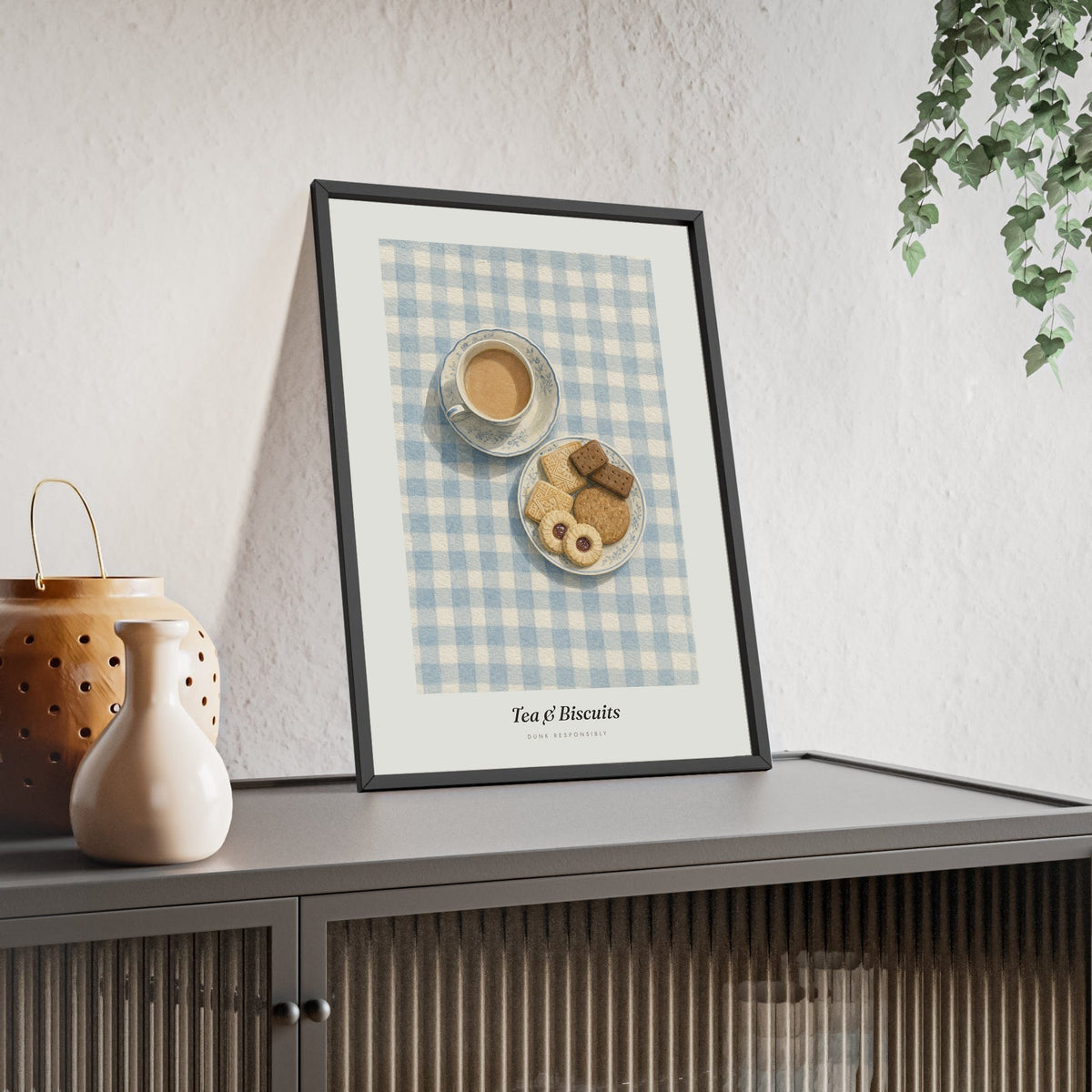 Tea and Biscuits Print framed and leaning on a sideboard