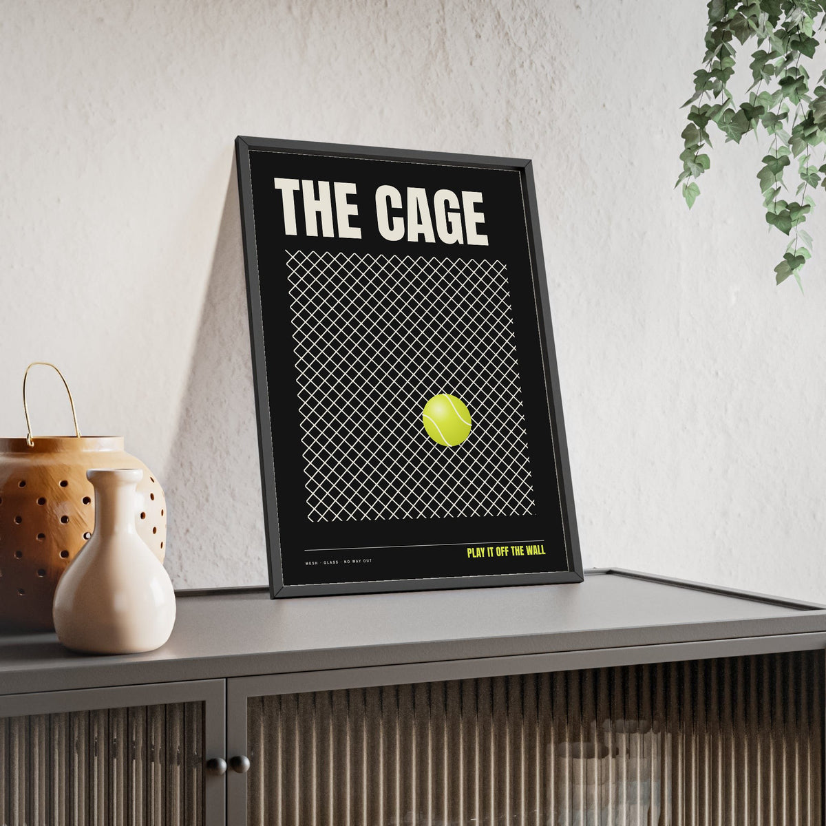 The Cage Padel print framed and leaning on a sideboard