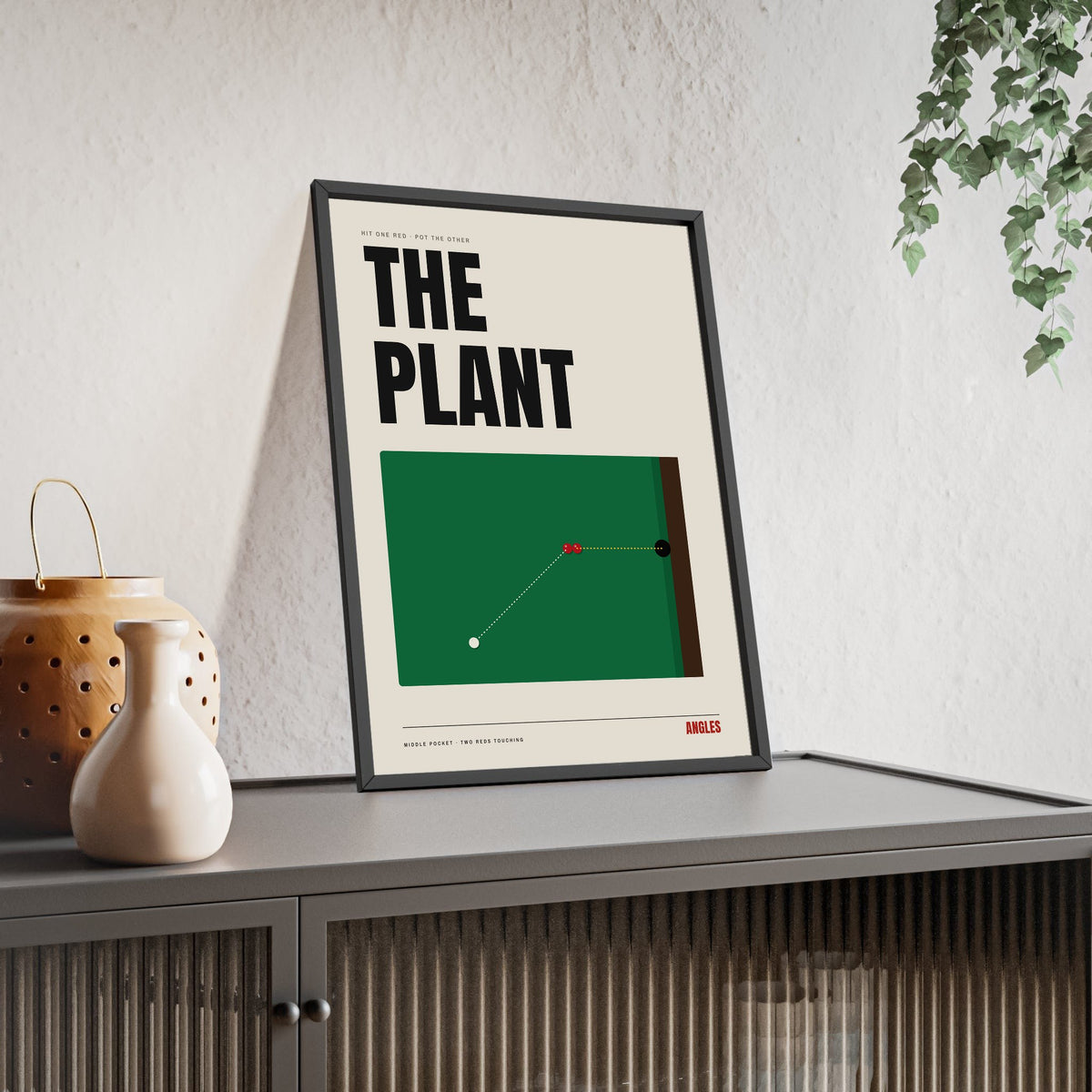 The Plant Snooker print framed and leaning on a sideboard