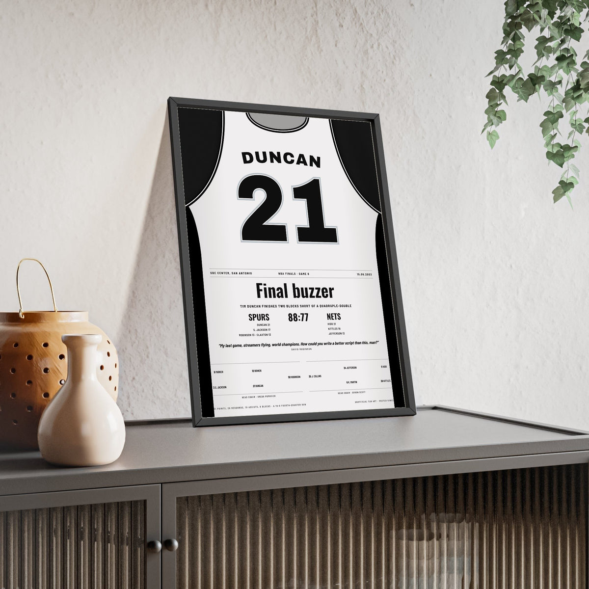 Tim Duncan 2003 NBA Finals Game 6 Poster - San Antonio Spurs 21 Near Quadruple-Double Jersey Print framed and leaning on a sideboard