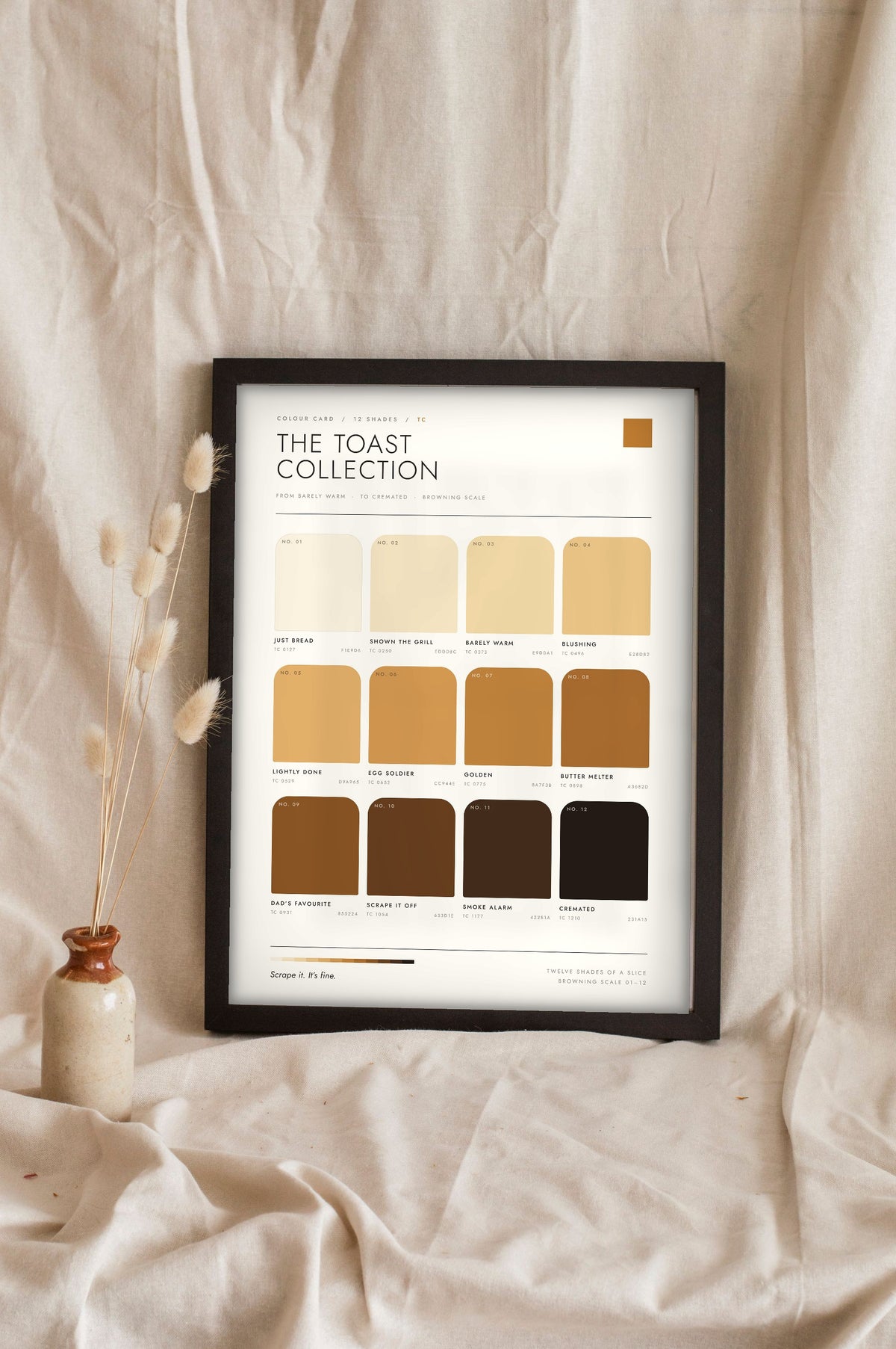 Toast Colour Chart in a black frame propped up on linen